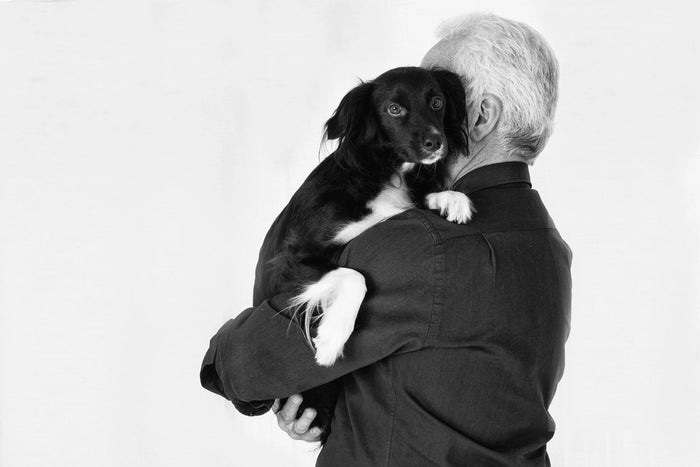 Man holding a puppy close in a warm hug